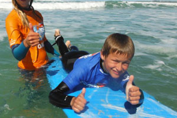 kid on surfboard as he learn to surf in Adelaide with coach
